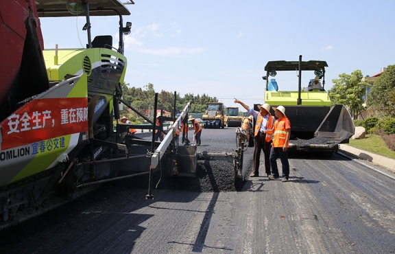 攤鋪機(jī)、壓路機(jī)等設(shè)備緊張有序運(yùn)行，高達(dá)170℃的瀝青混合料炙烤著公路人